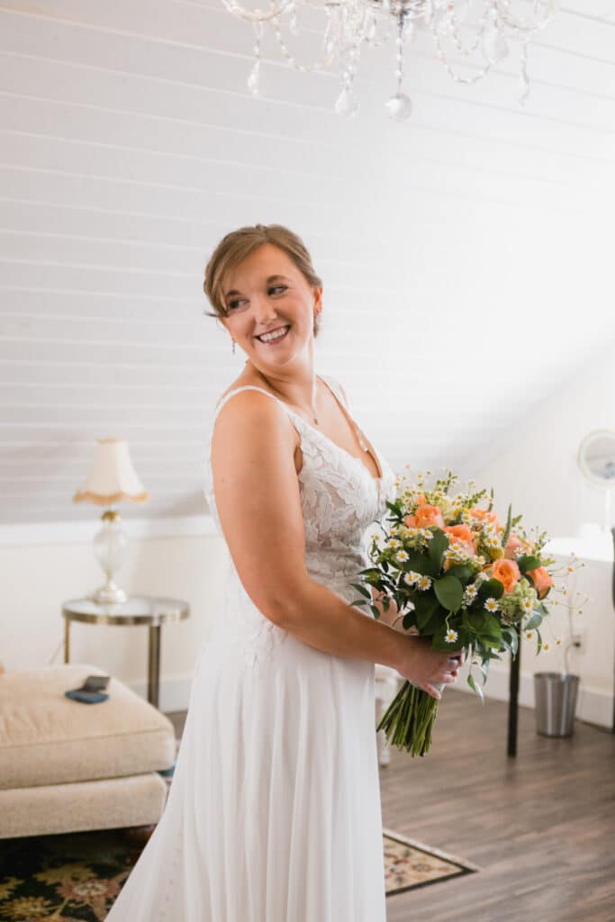 Beautiful bride awaiting the start to her perfect day at the Round Barn Farm wedding venue in Red Wing, Minnesota. She holds a beautiful floral bouquet in one of the top Minnesota Wedding Venues.