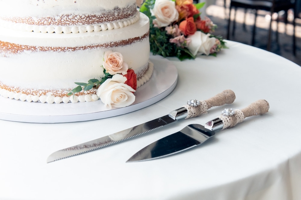 Fall Wedding Inspiration for the Best Minnesota Wedding Venues 1 Wedding cake adorned with orange, pink and red roses, one of the trending fall wedding color palettes. Minnesota Wedding Venues.