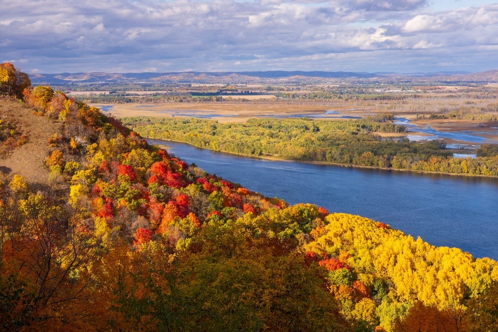 The Best Minnesota Fall Getaways 4 A view of the Mississippi River with vibrant Minnesota fall colors.