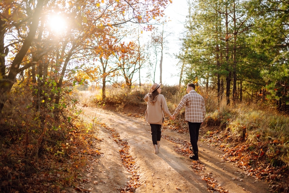 The Best Minnesota Fall Getaways 7 Couple walking hand in hand down a country road during fall in Red Wing MN